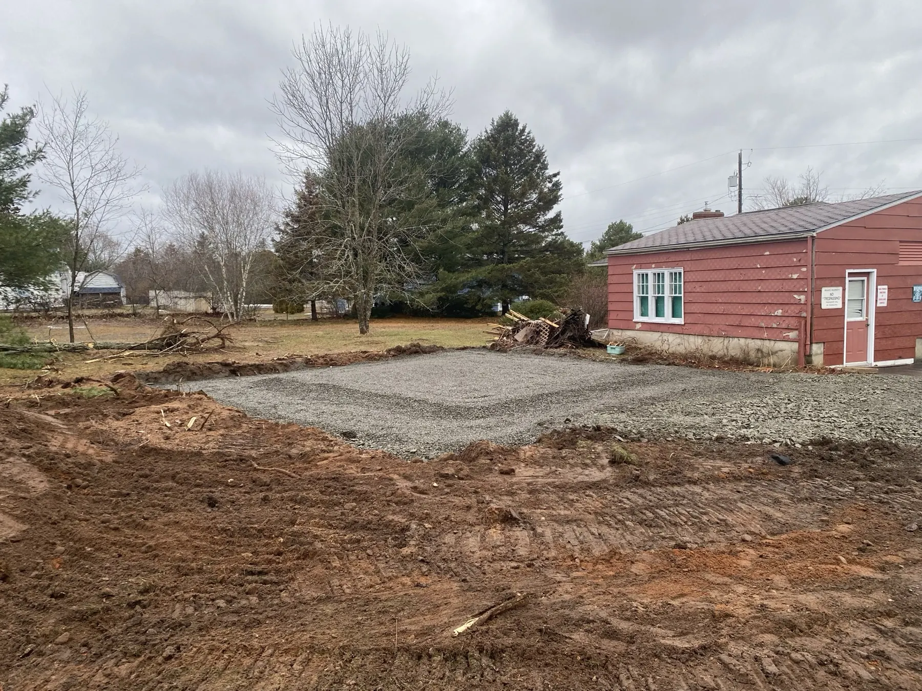Freshly prepared gravel building pad beside a home